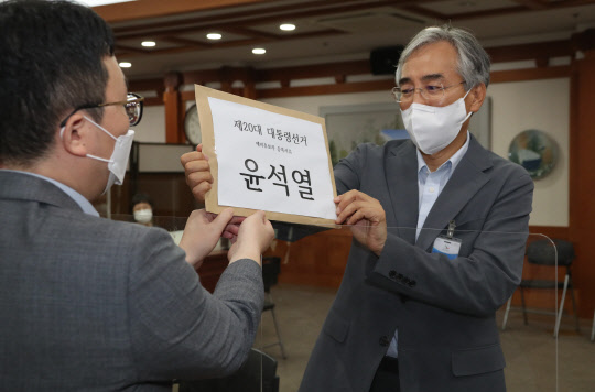 윤석열 전 검찰총장 대선캠프 정책 총괄을 맡은 이석준 전 국무조정실장(오른쪽)이 12일 오전 경기도 과천시 중앙선관위에서 윤 전 총장을 대리해 제20대 대통령선거 예비후보 등록을 하고 있다.연합뉴스